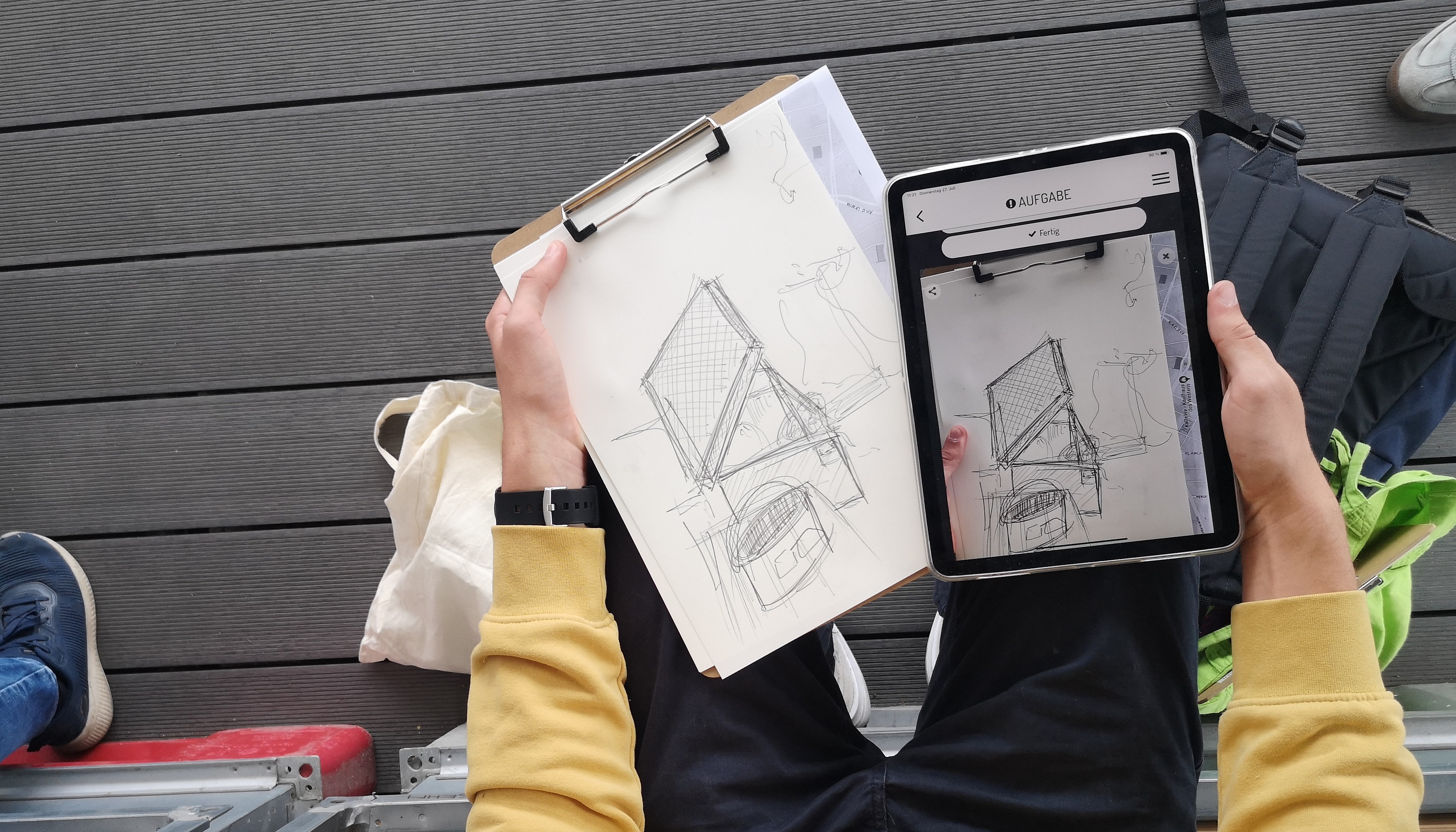 Jugendliche schaut auf Tablet und Zeichnung